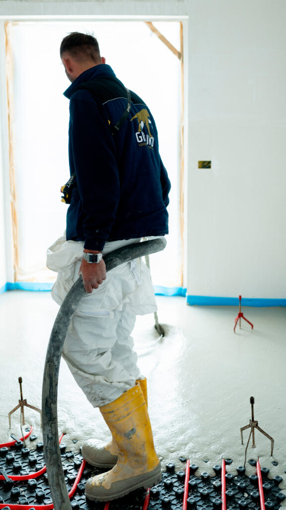 Operaio edile impegnato nella posa di massetto autolivellante