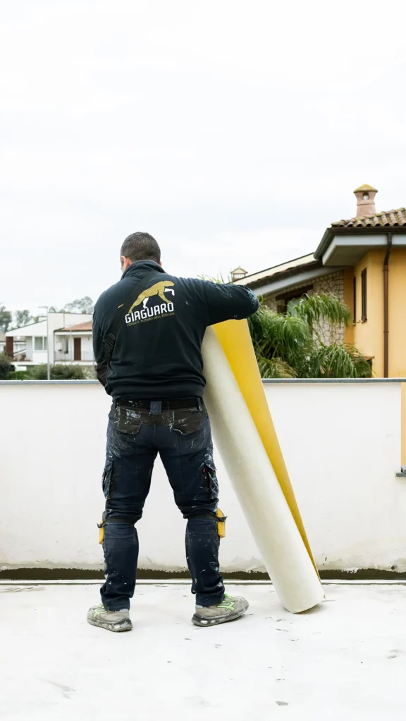 Operaio di un'impresa edile multiservizio impegnato nell'impermeabilizzazione di un edificio