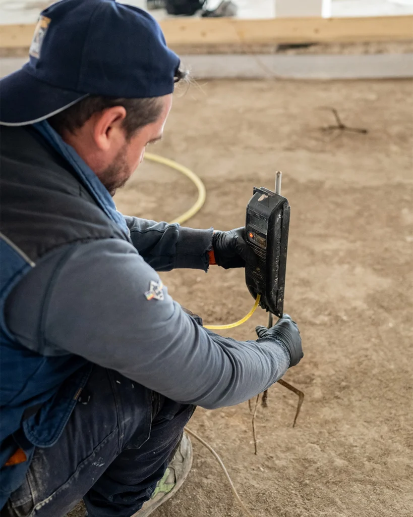Operaio impegnato nella preparazione del cantiere per la posa di massetto a basso spessore